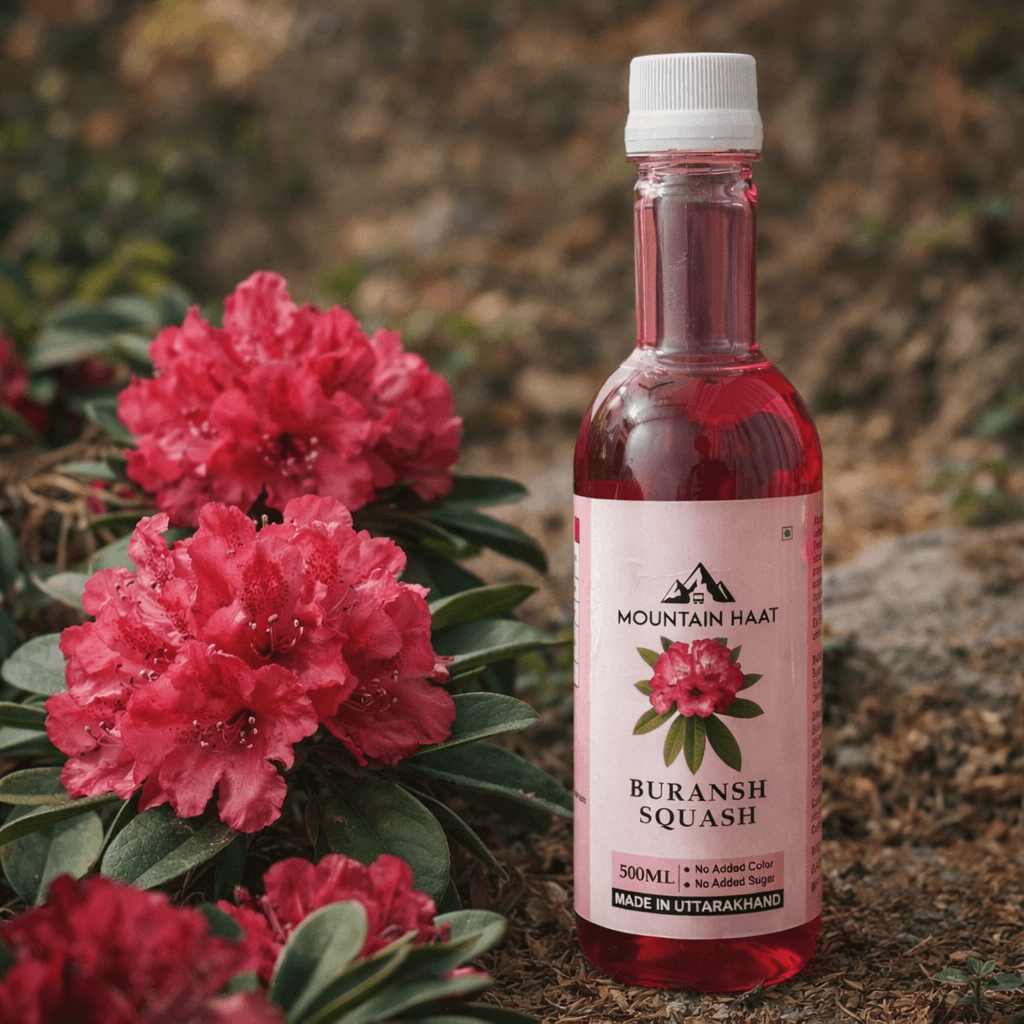 Buransh squash bottle placed with fresh Himalayan rhododendron flowers