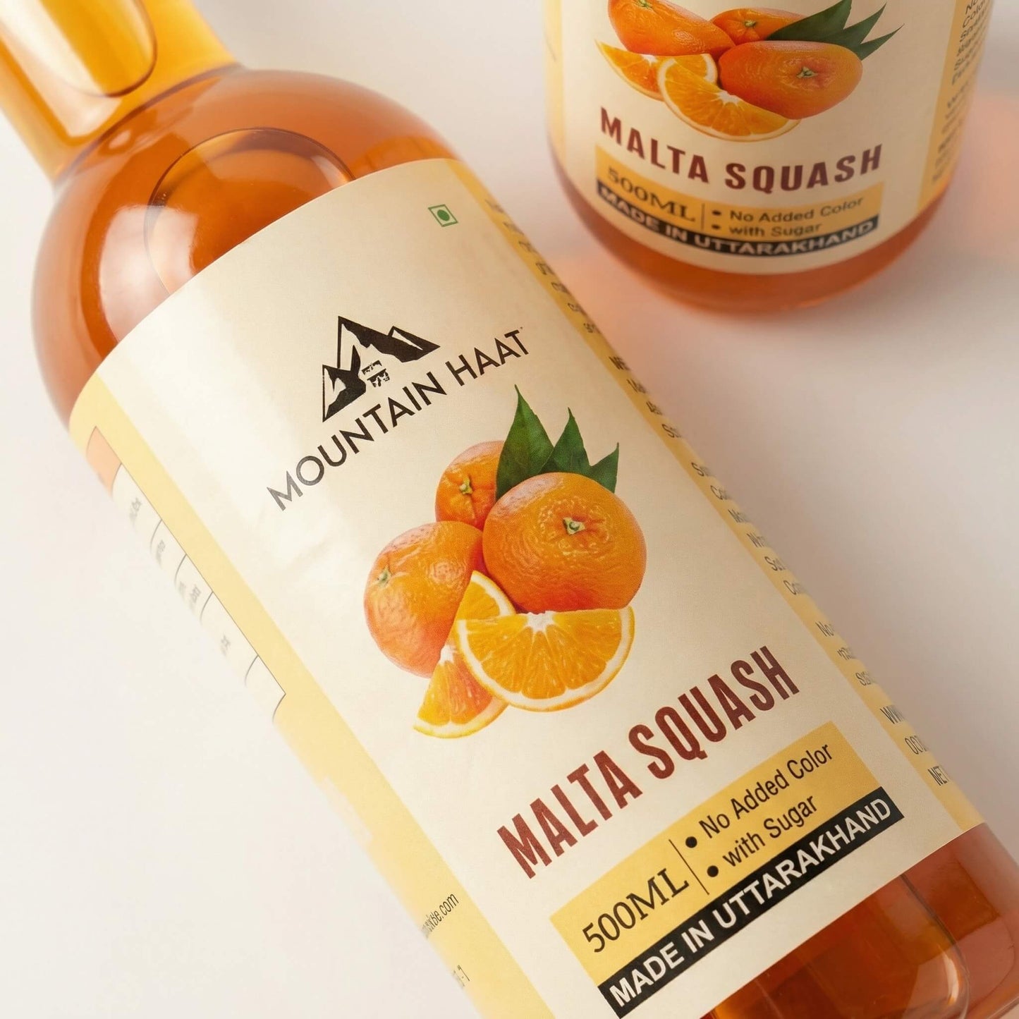 Close-up of Mountain Haat Malta Squash 500ml label showing no added color and made in Uttarakhand.