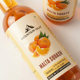 Close-up of Mountain Haat Malta Squash 500ml label showing no added color and made in Uttarakhand.